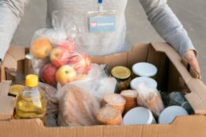 A donation box filled with food items and monetary contributions.
